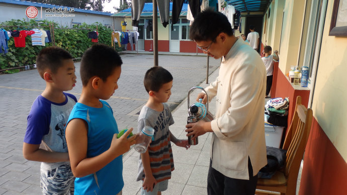 
生活老師為小學員添水，給予悉心照顧和安全教育