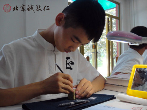 
篆刻班小學(xué)員在認(rèn)真專注的習(xí)練篆刻

