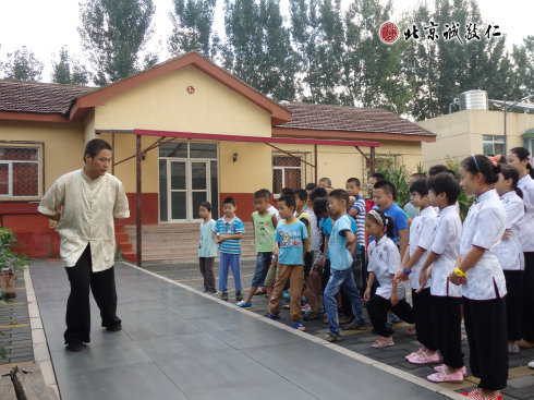 太極拳教練認(rèn)真指導(dǎo)小學(xué)員步步禪動作要領(lǐng)