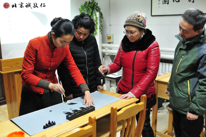 配圖：指導(dǎo)老師示范無(wú)墨書法